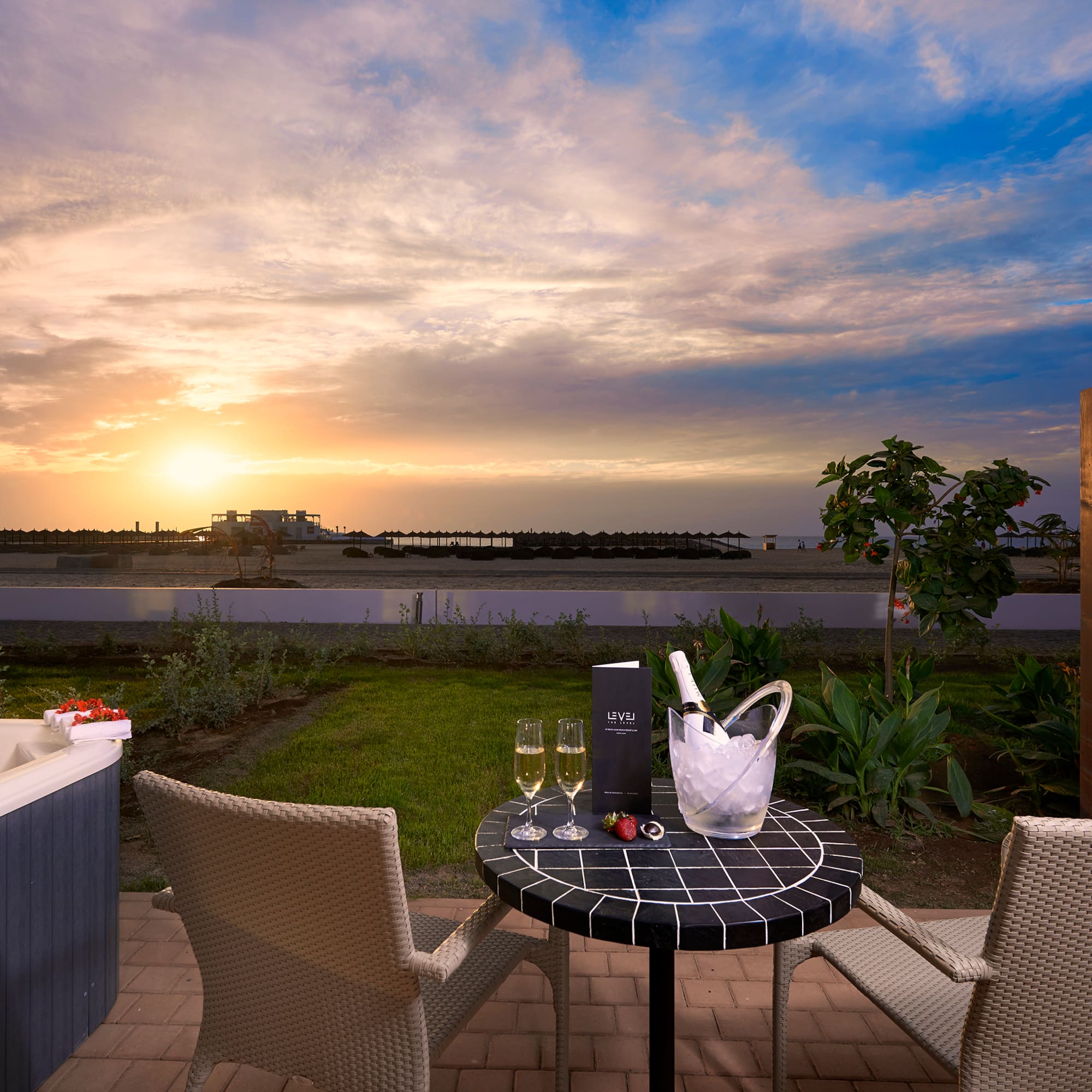 a table with wine glasses and a hot tub in the background