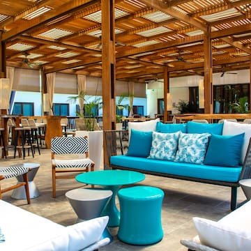 a patio with a blue couch and white tables