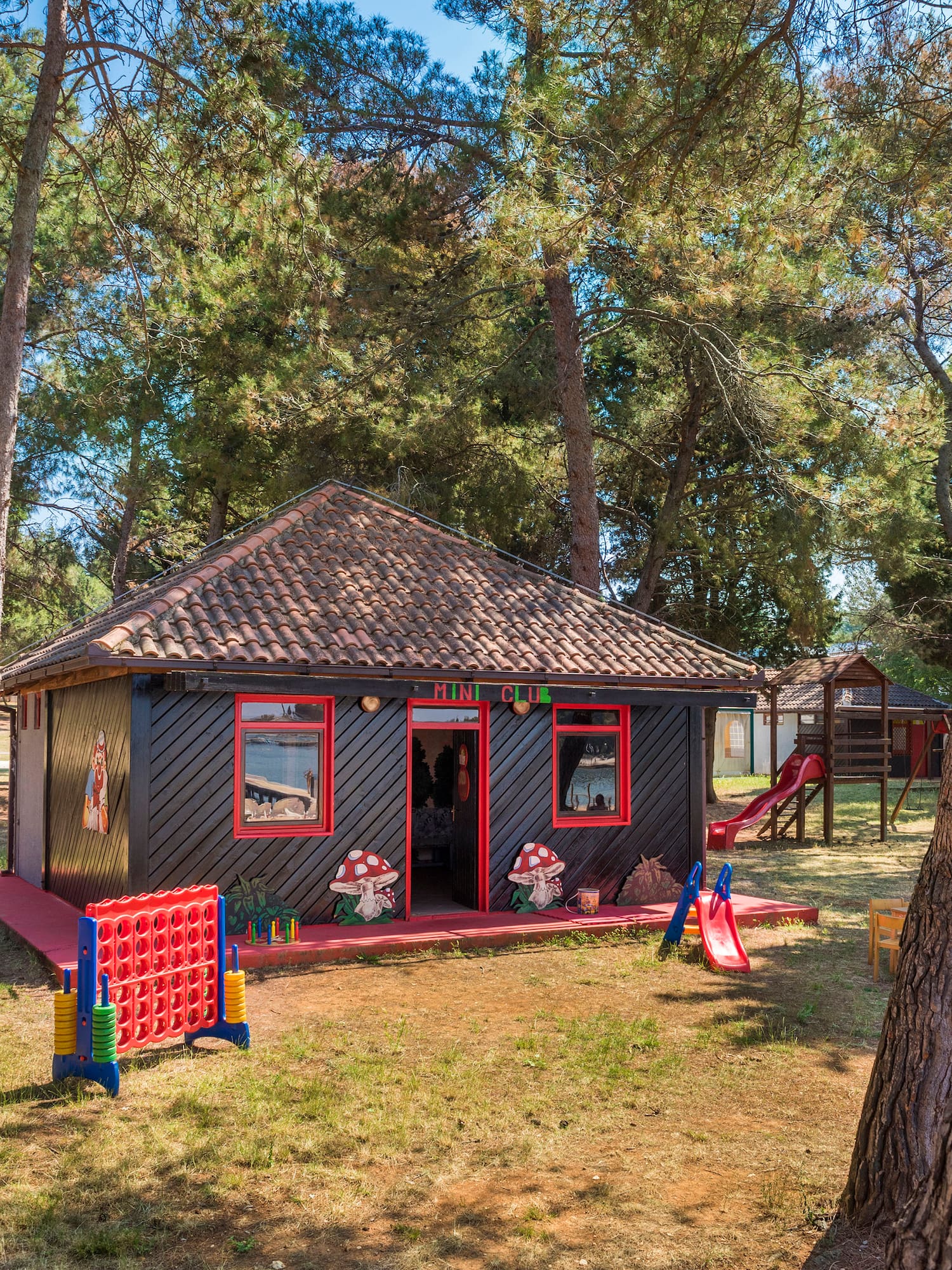 a small house with a slide and trees