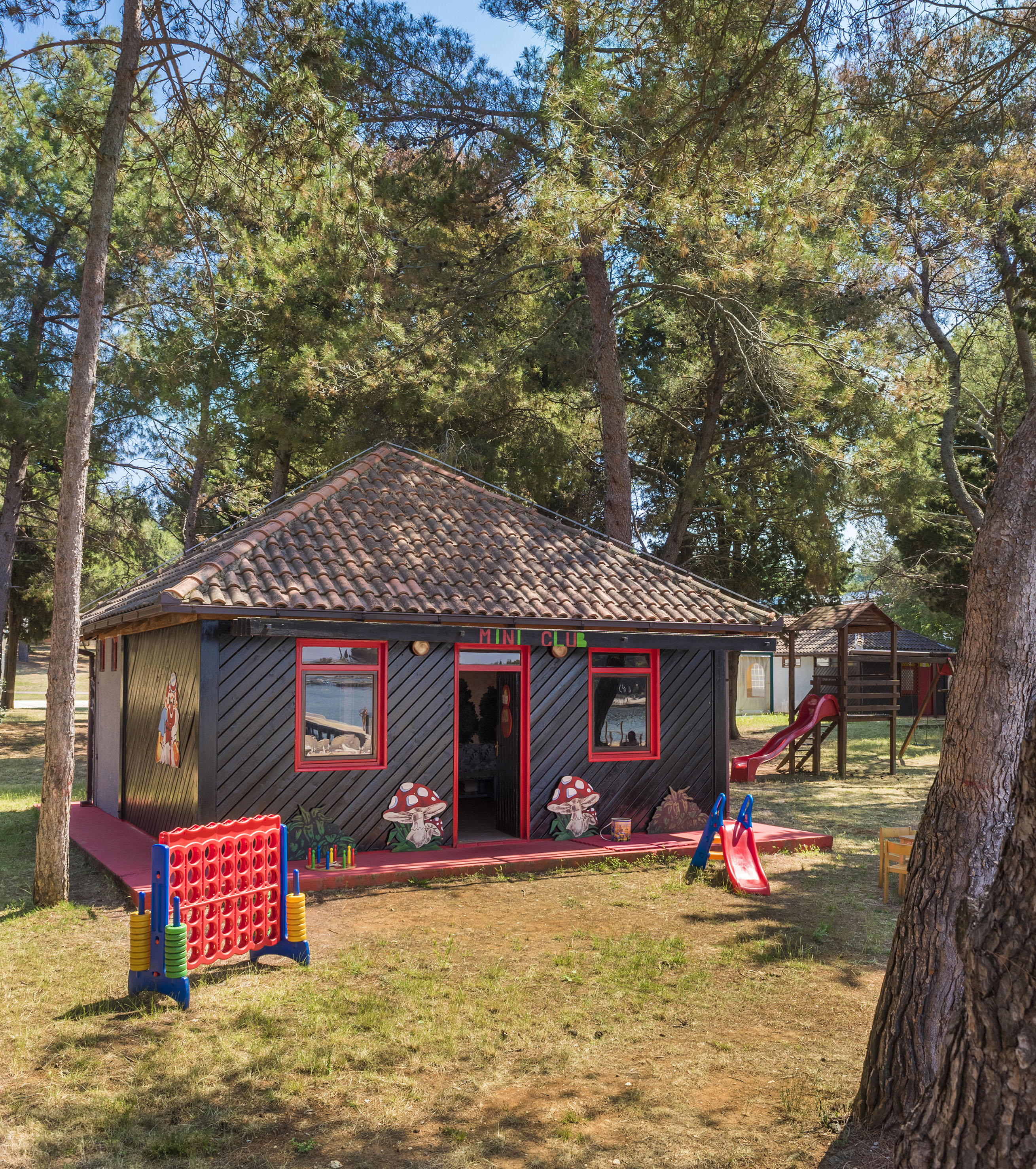 a small house with a slide and trees