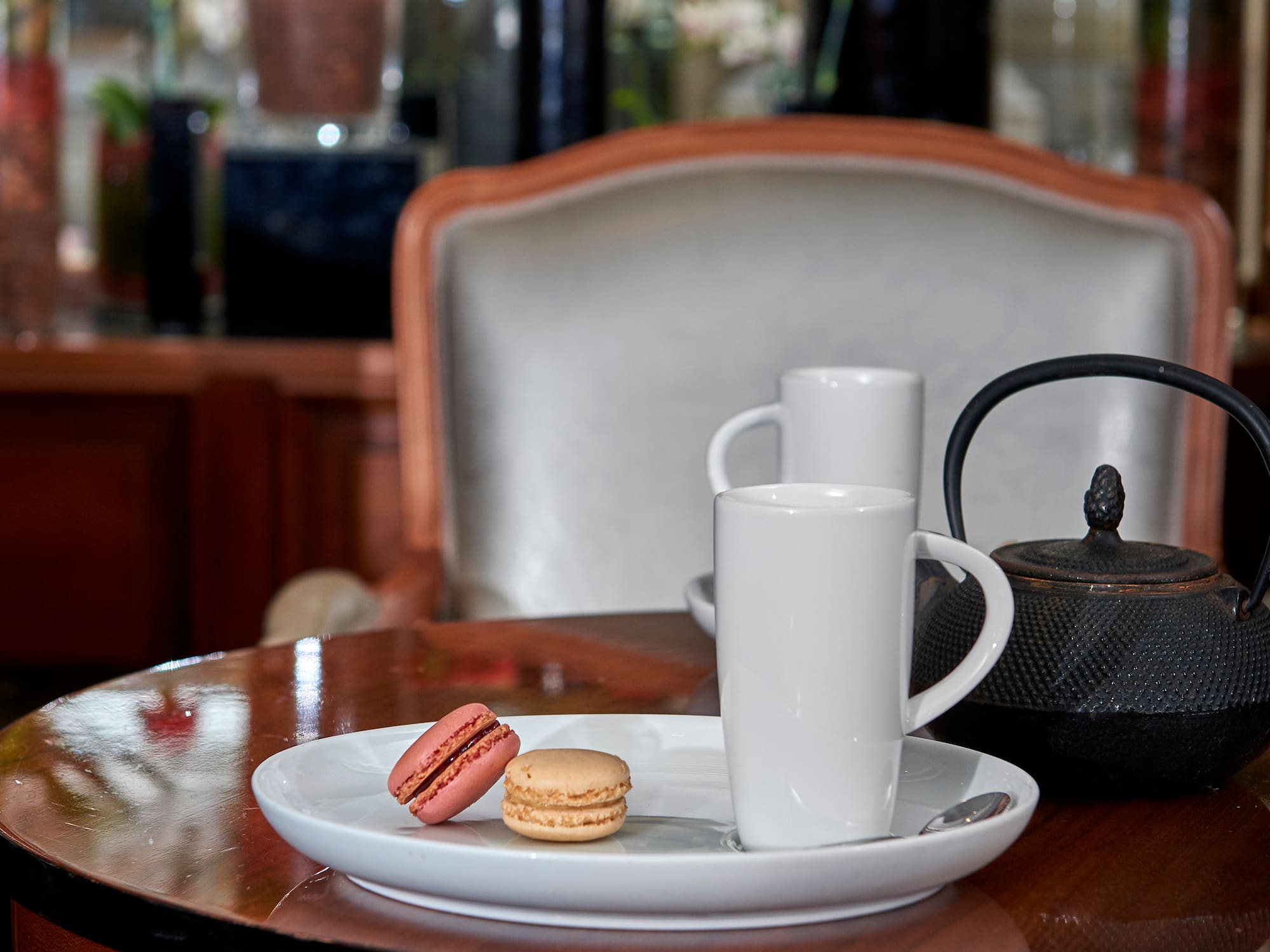 A plate of cookies and a teapot sit on the table.