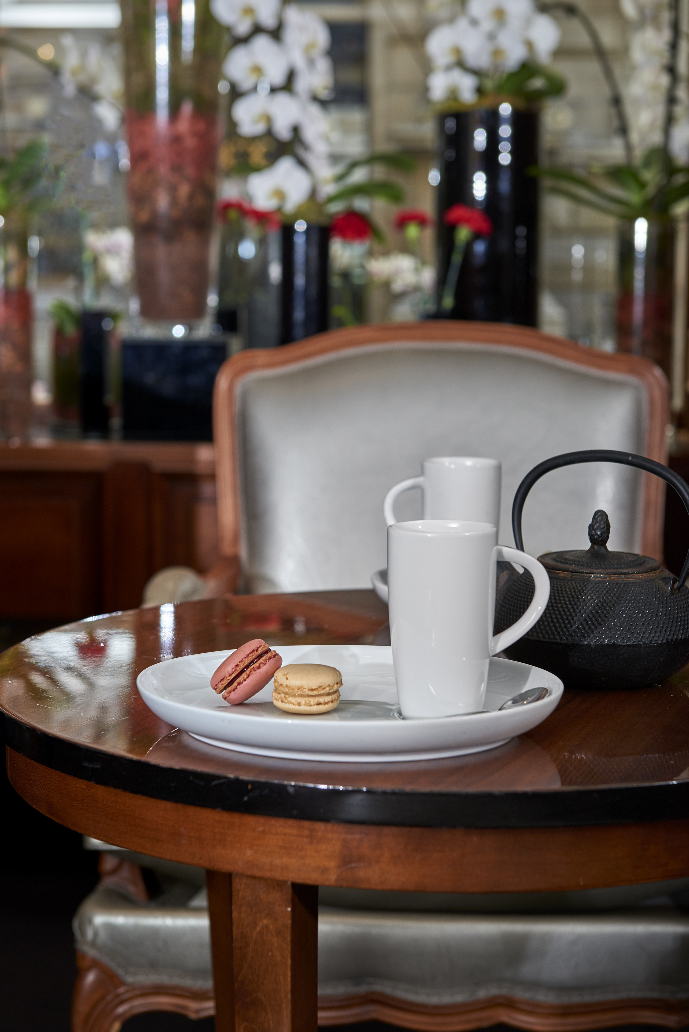 A plate of cookies and a teapot sit on the table.