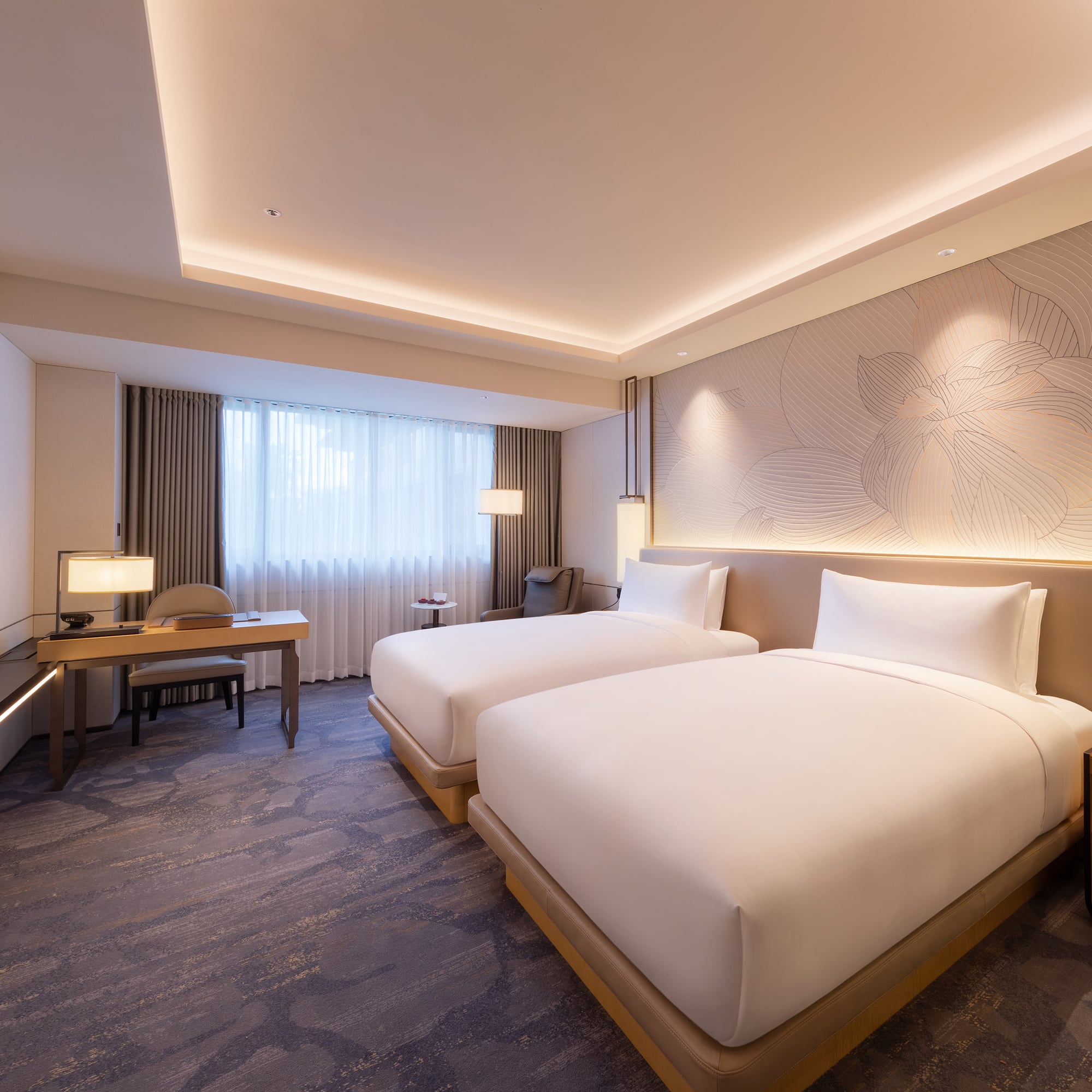 a room with two beds and a desk