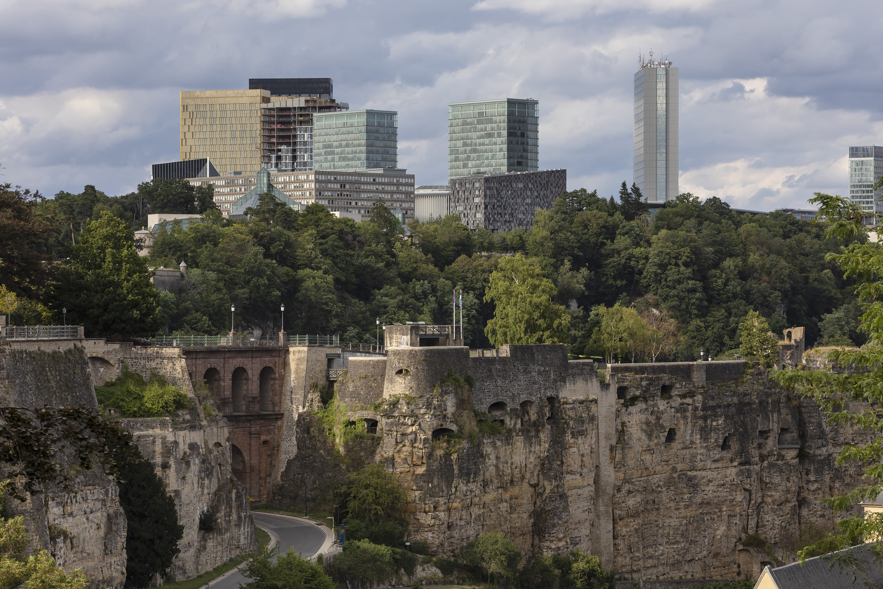 a stone wall with trees and buildings in the background