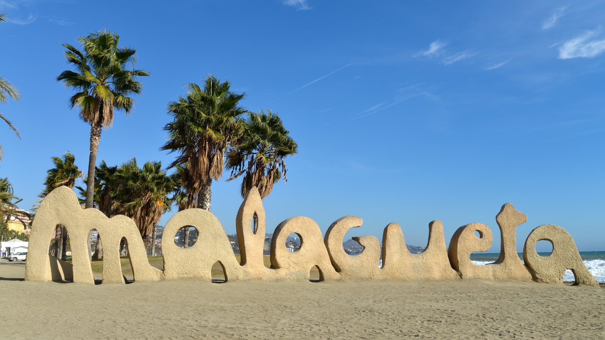 a large sand sculpture of a beach with palm trees and blue sky