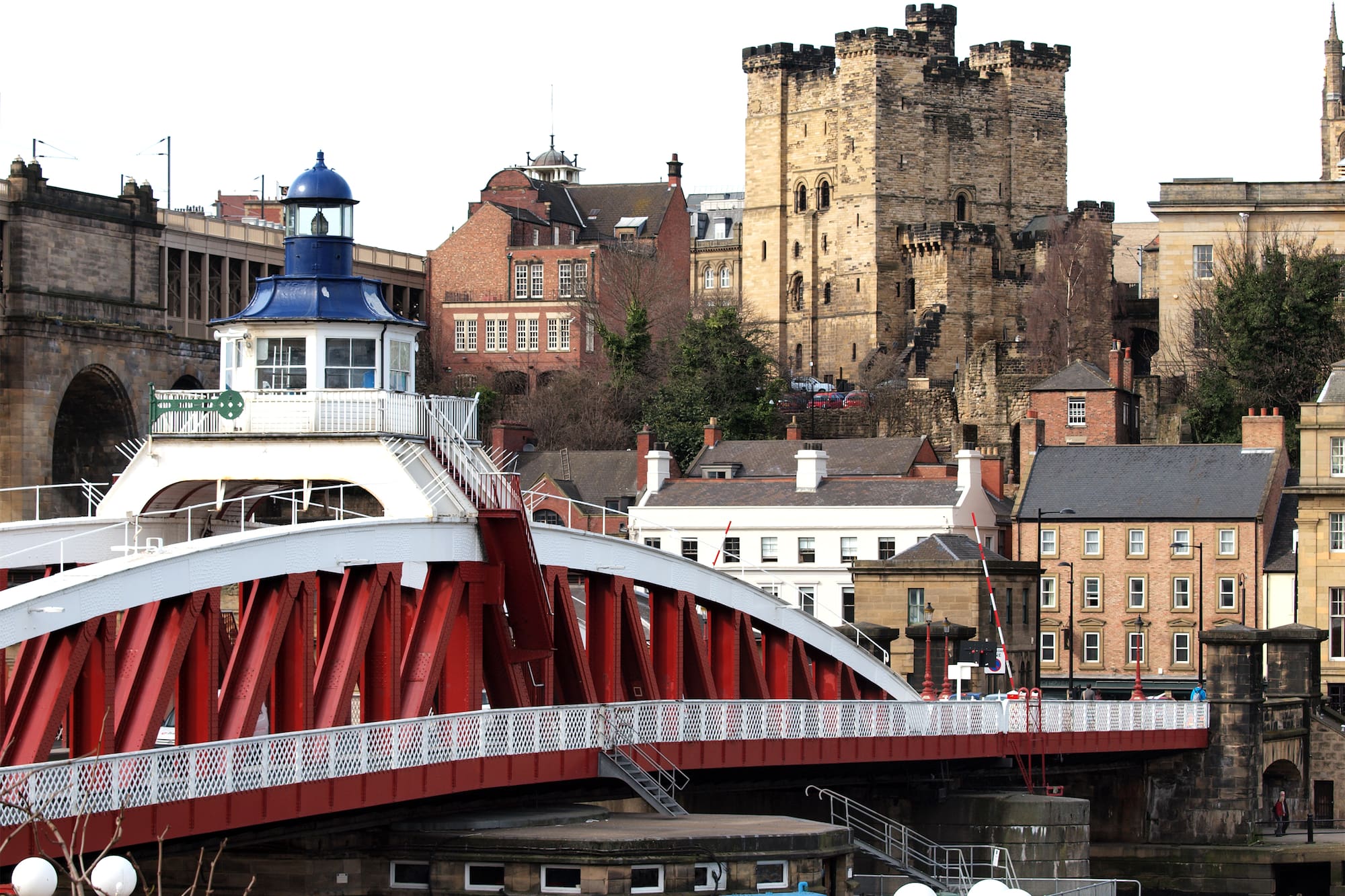 a bridge over a river with a lighthouse