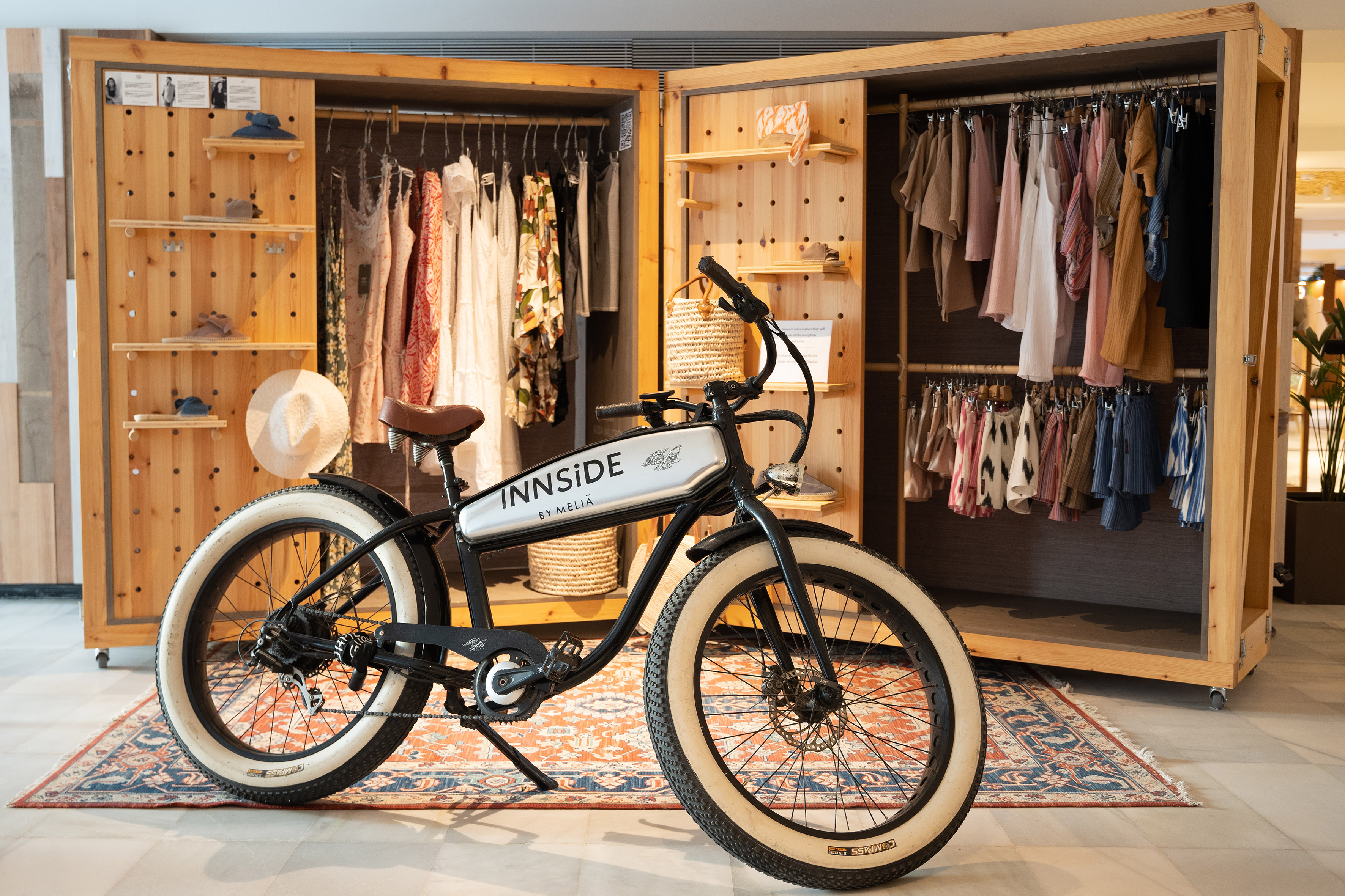 a bicycle in a room with clothes on the wall