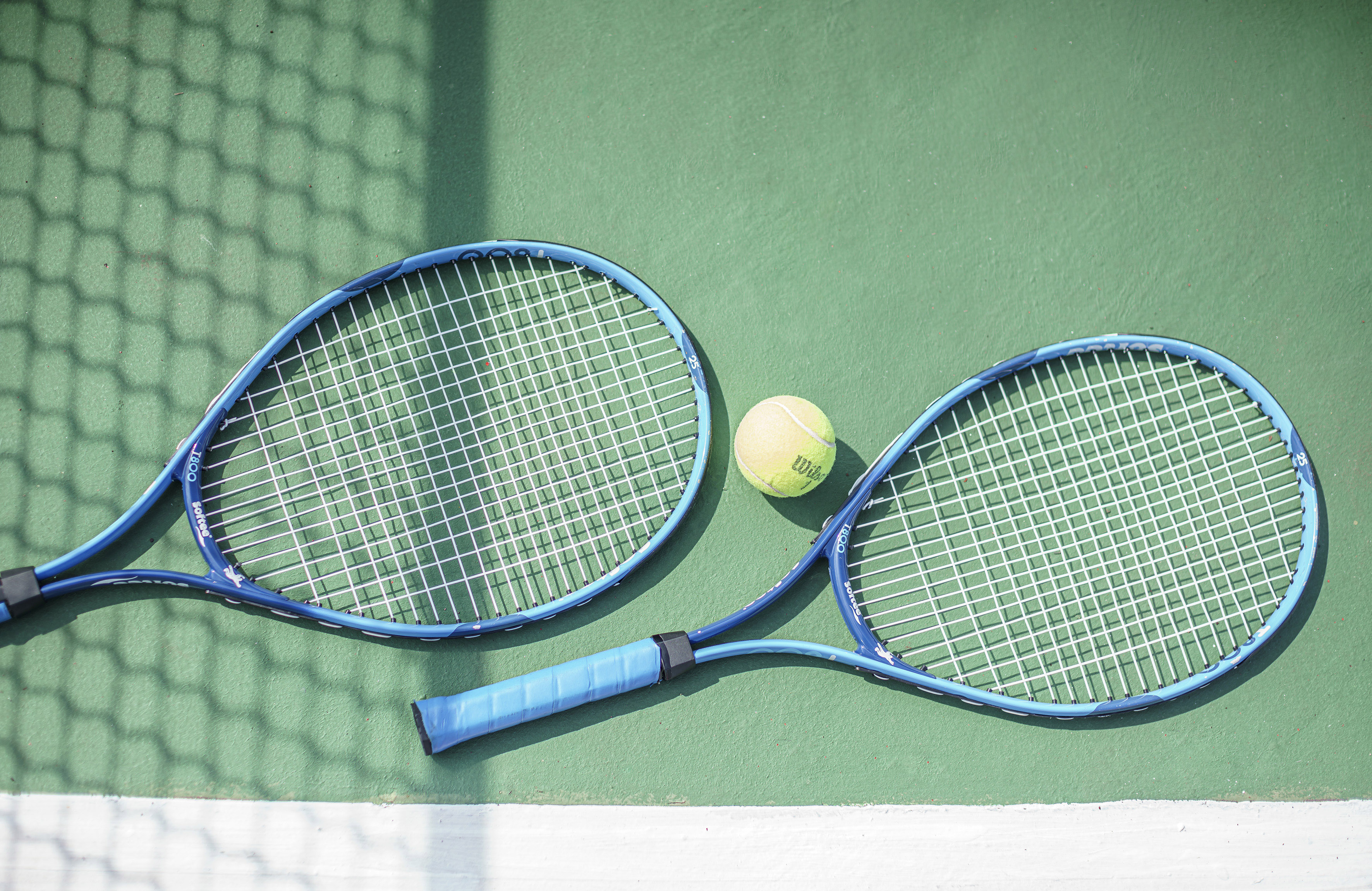 a tennis rackets and a ball on a court