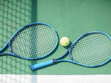 a tennis rackets and a ball on a court