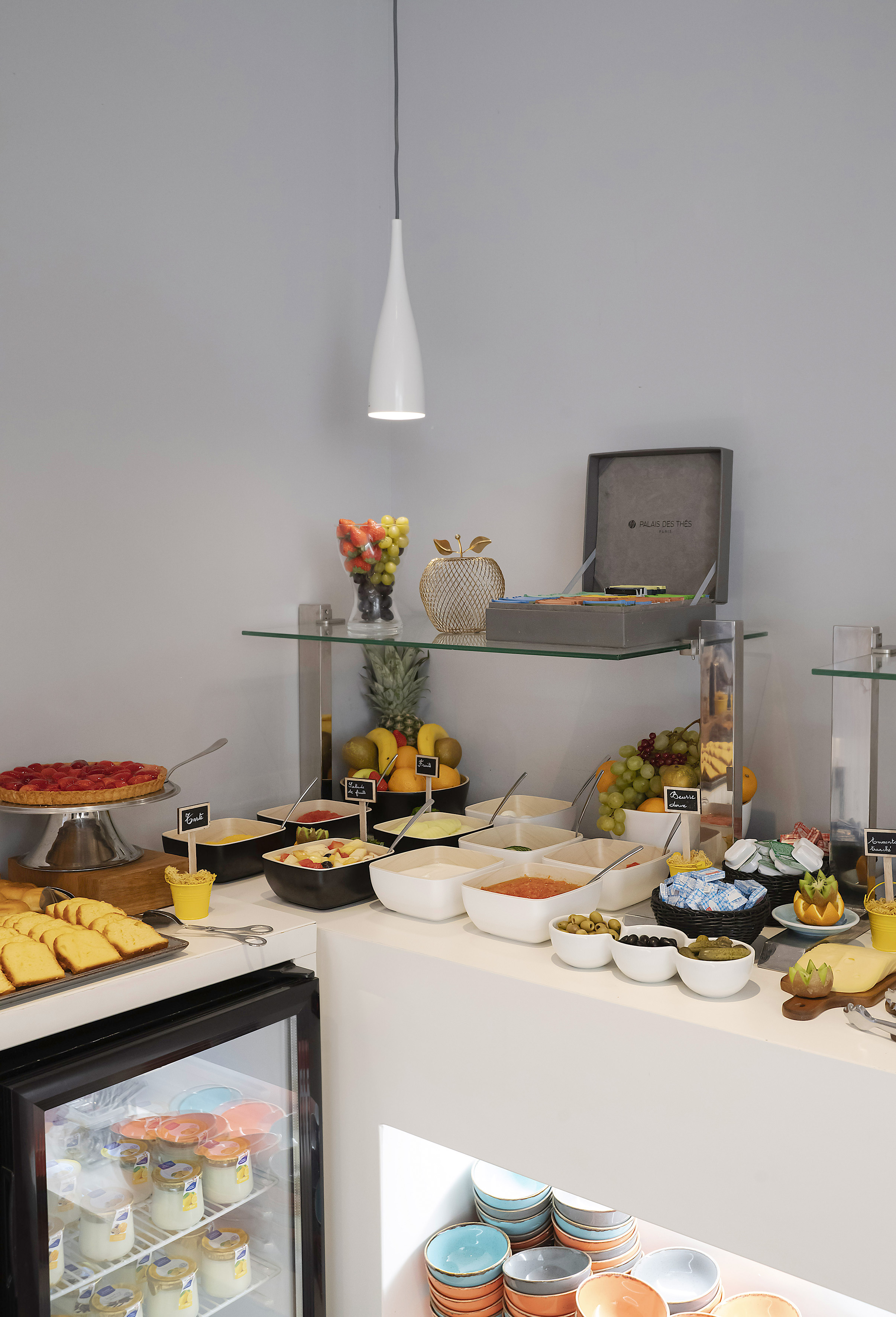 Diverse breakfast buffet with fresh fruit, pastries, yogurts, and savory dishes.