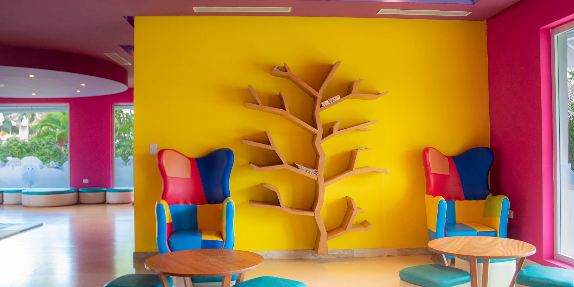 a colorful room with a tree shelf and chairs