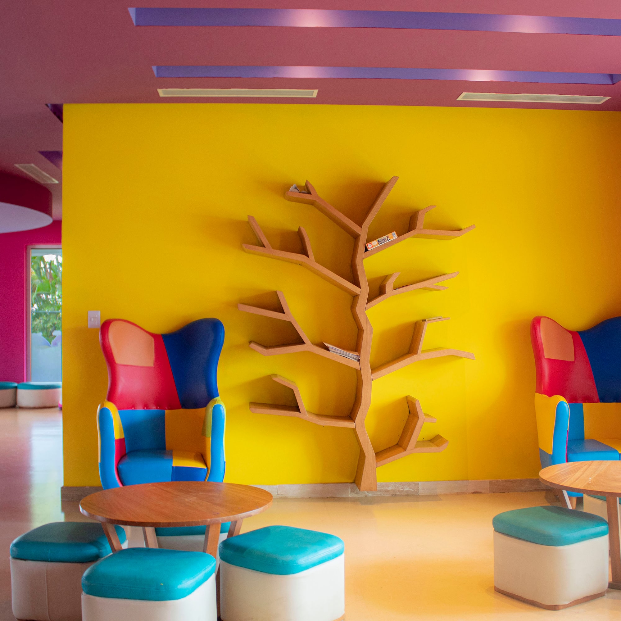 a colorful room with a tree shelf and chairs