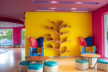 a colorful room with a tree shelf and chairs