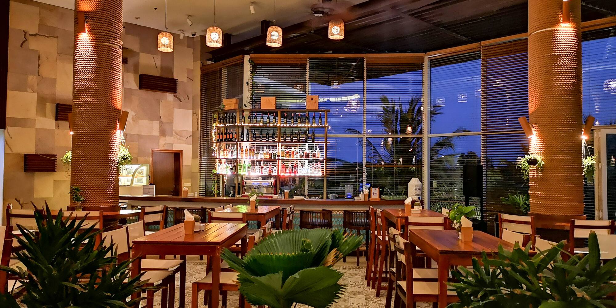 a room with tables and chairs and plants