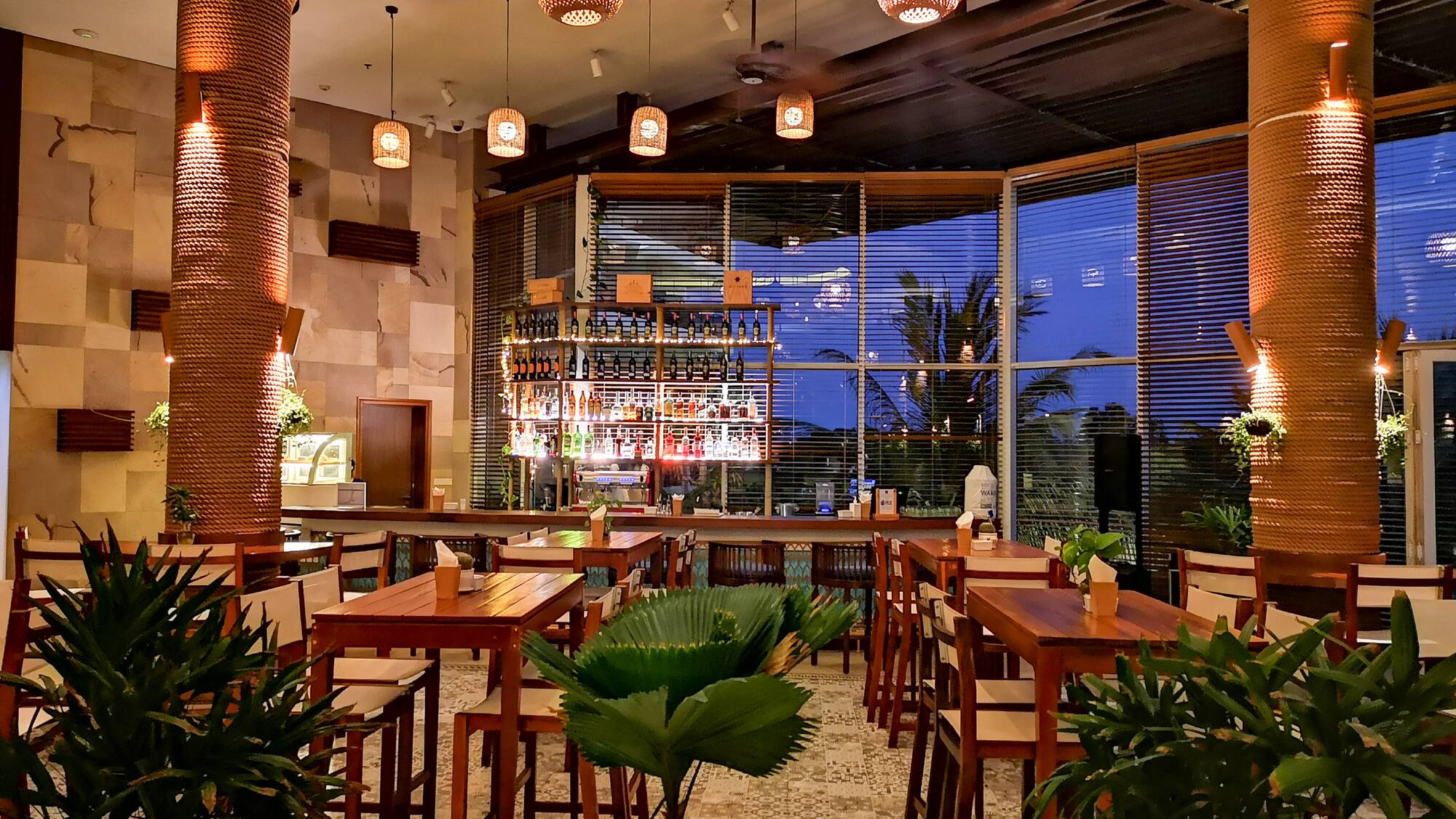 a room with tables and chairs and plants