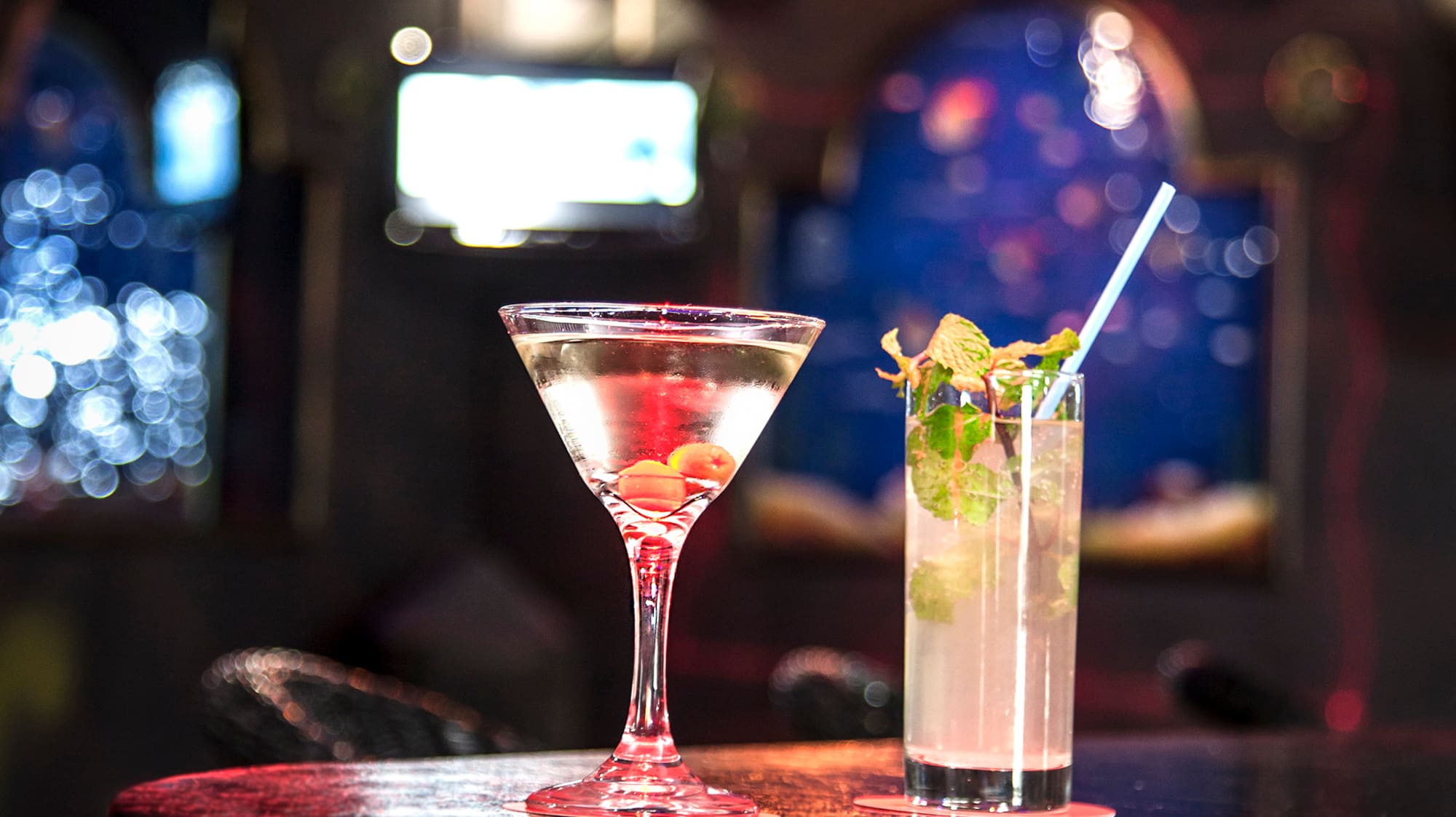 a glass of liquid and a drink on a bar