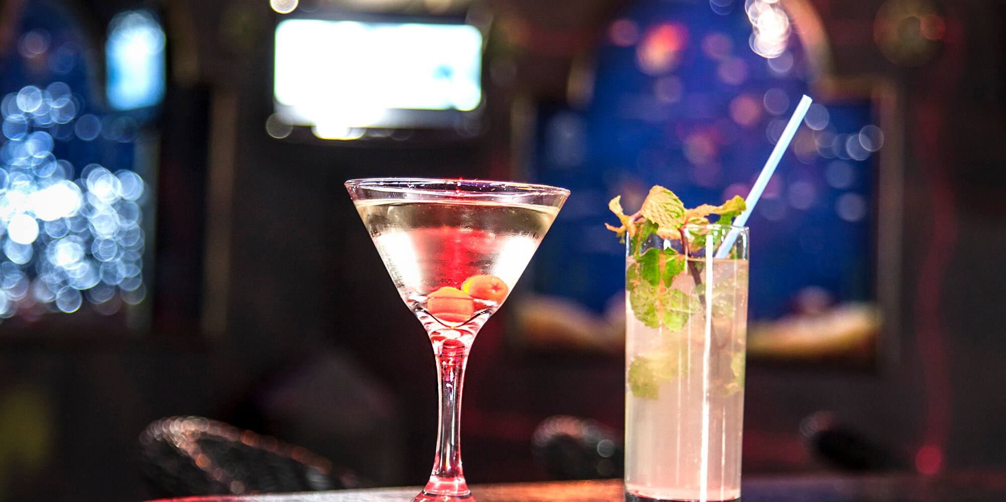 a glass of liquid and a drink on a bar