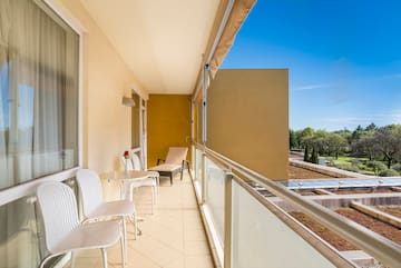 a balcony with chairs and a table