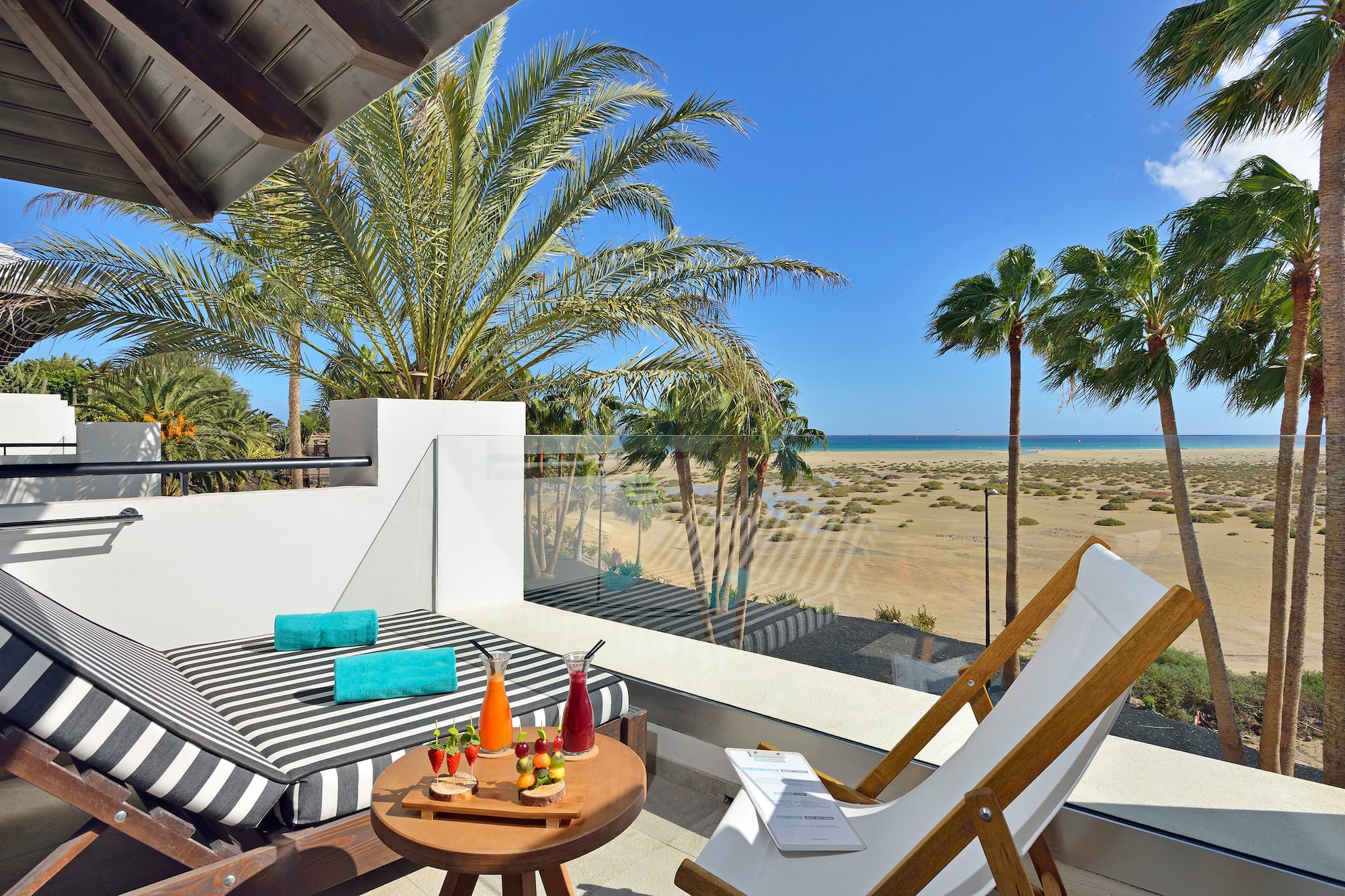 a deck with a table and chairs and a beach view