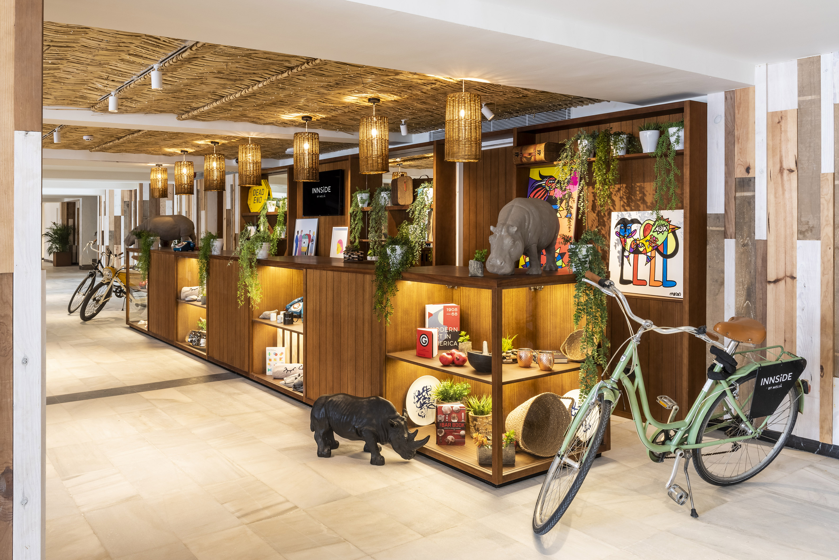 INNSIDE hotel lobby with safari-themed retail display, rhino sculptures, and bikes.