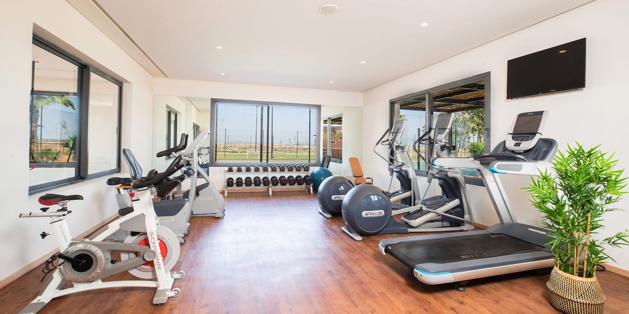 a room with exercise equipment and a wood floor