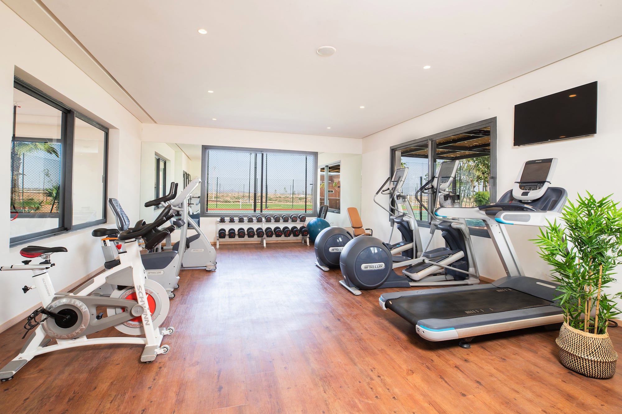 a room with exercise equipment and a wood floor