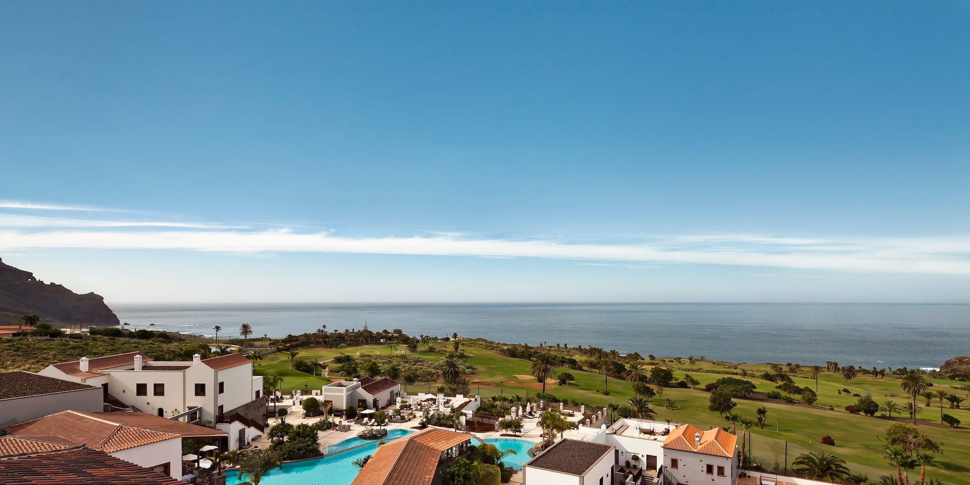 a pool and buildings next to a body of water