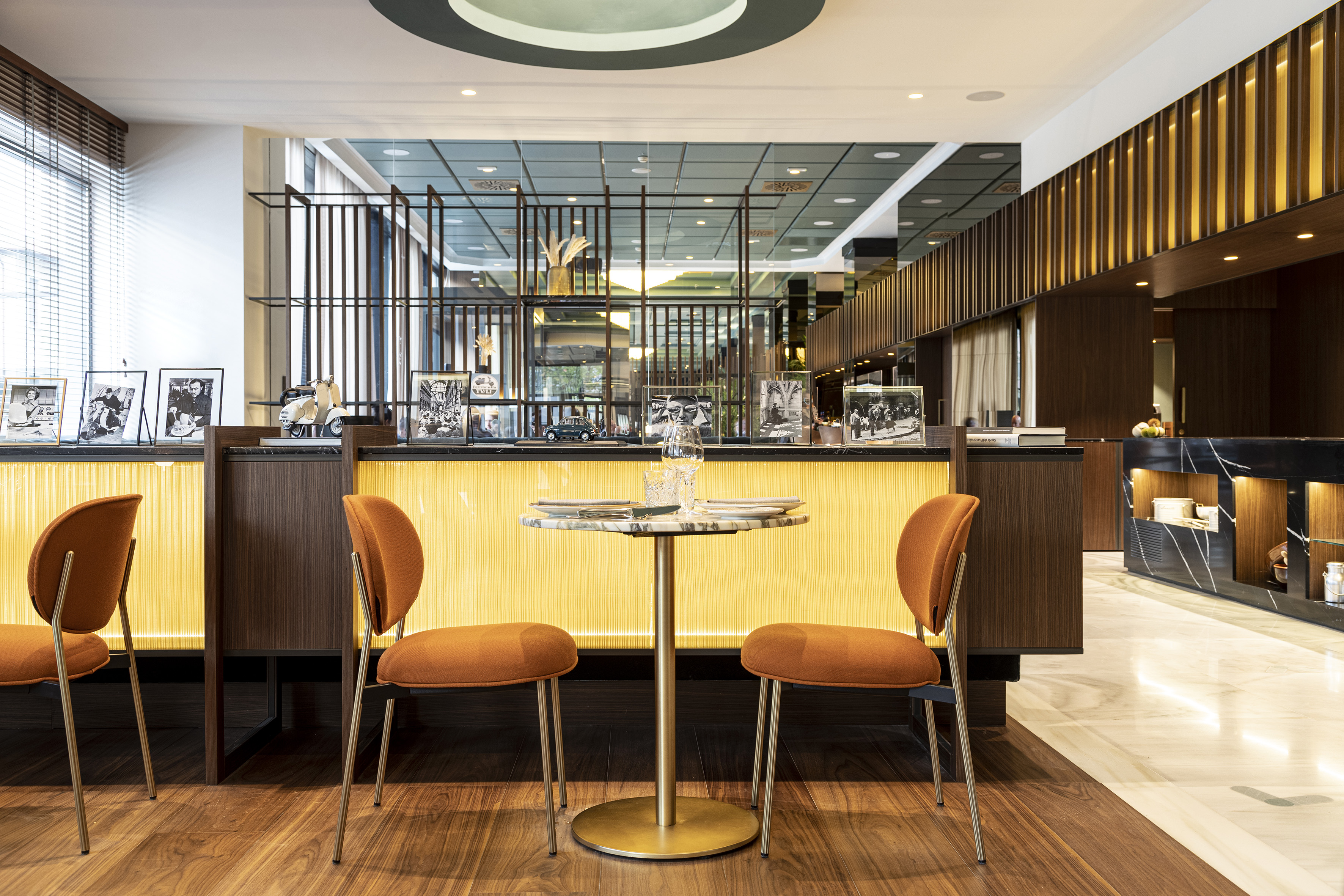 Stylish cafe with orange chairs, marble table, and retro photo decor.