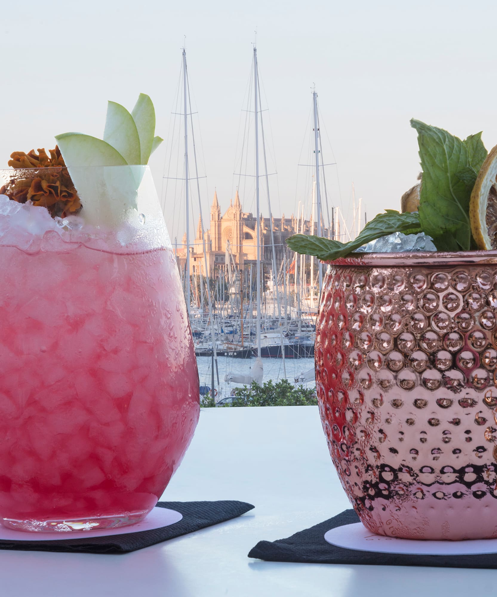 two glasses with ice and fruit on them
