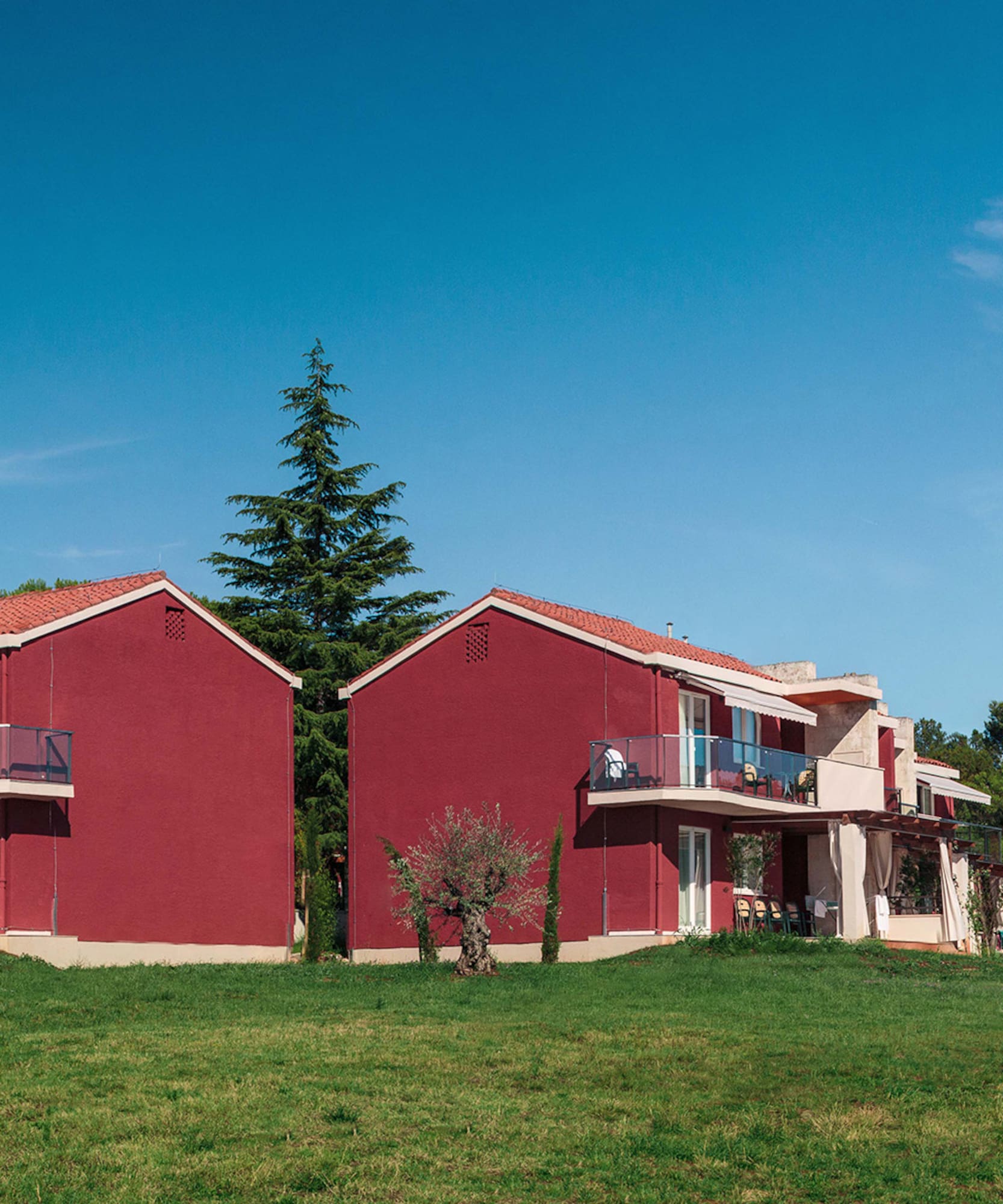 a group of red houses with trees in the background