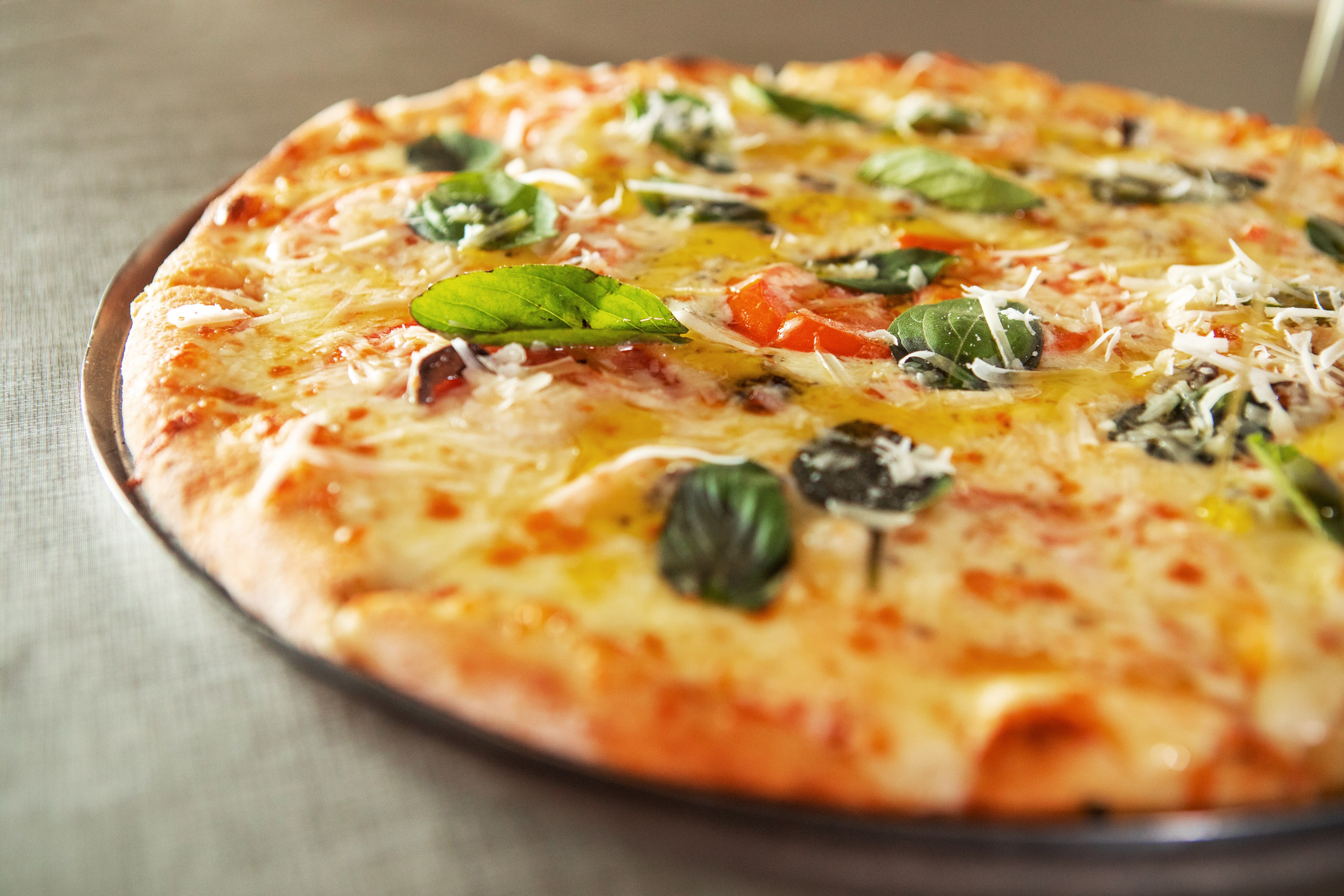 Margherita pizza with fresh basil, mozzarella, and tomatoes.