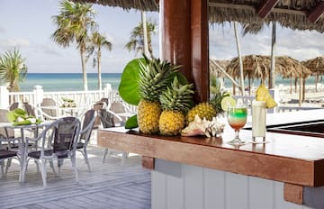 a bar with a drink and pineapples on it