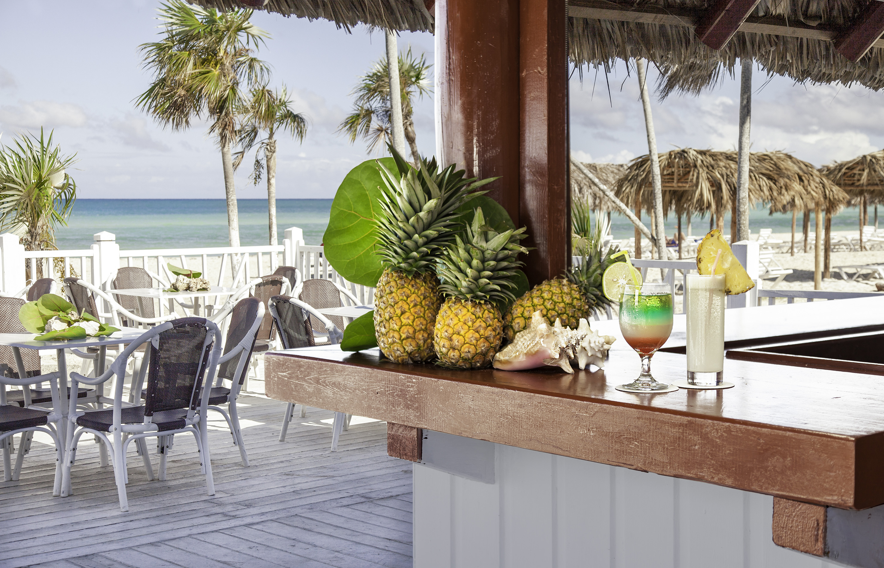 a bar with a drink and pineapples on it