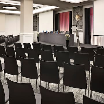 a room with black chairs and a podium
