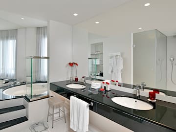 a bathroom with a black countertop and white tile floor