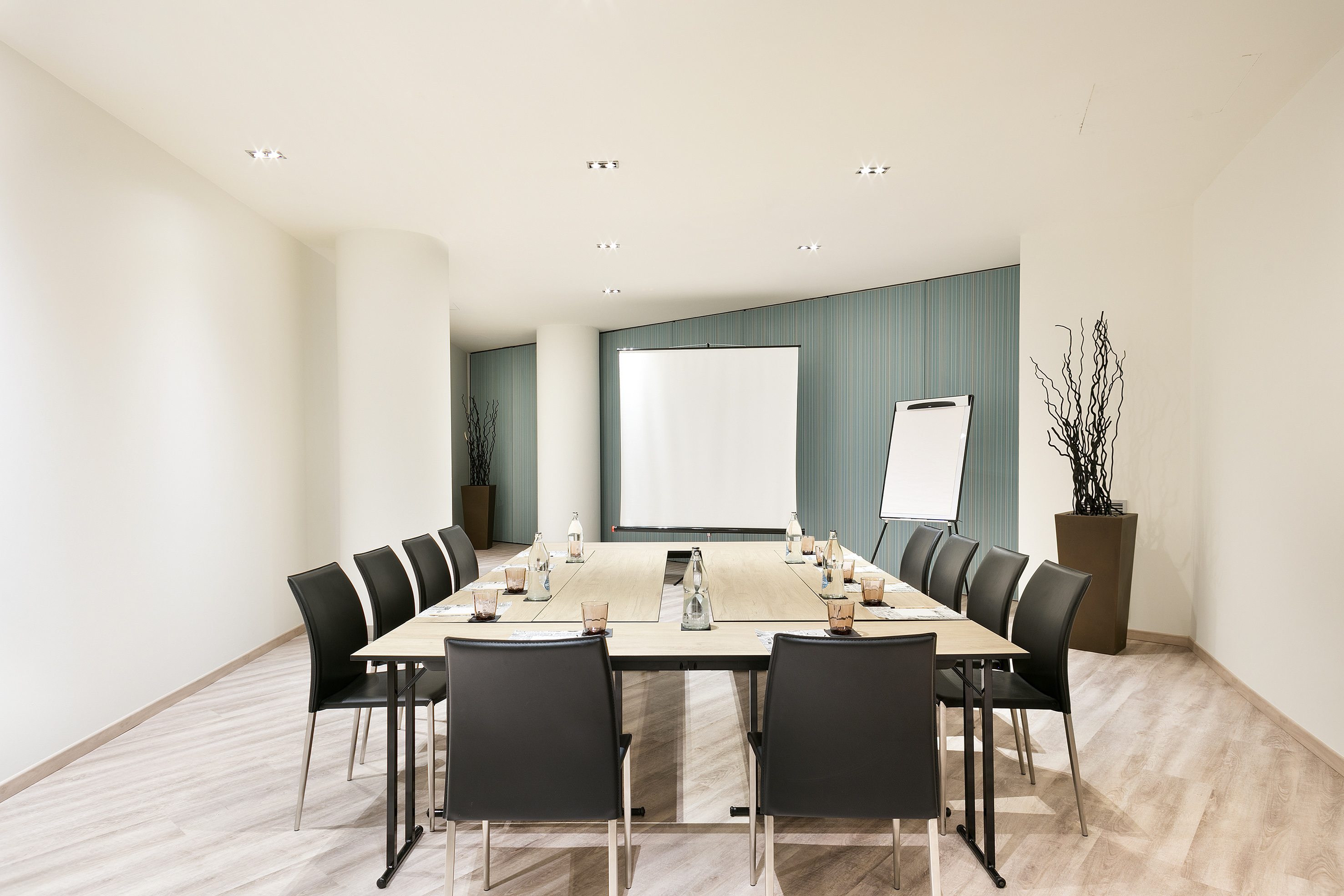 Modern meeting room with U-shaped table, projector screen, and whiteboard for presentations. - GOTIC - فندق برشلونة كوندال مار(Condal Mar) المنتسب لـ Melia, برشلونة