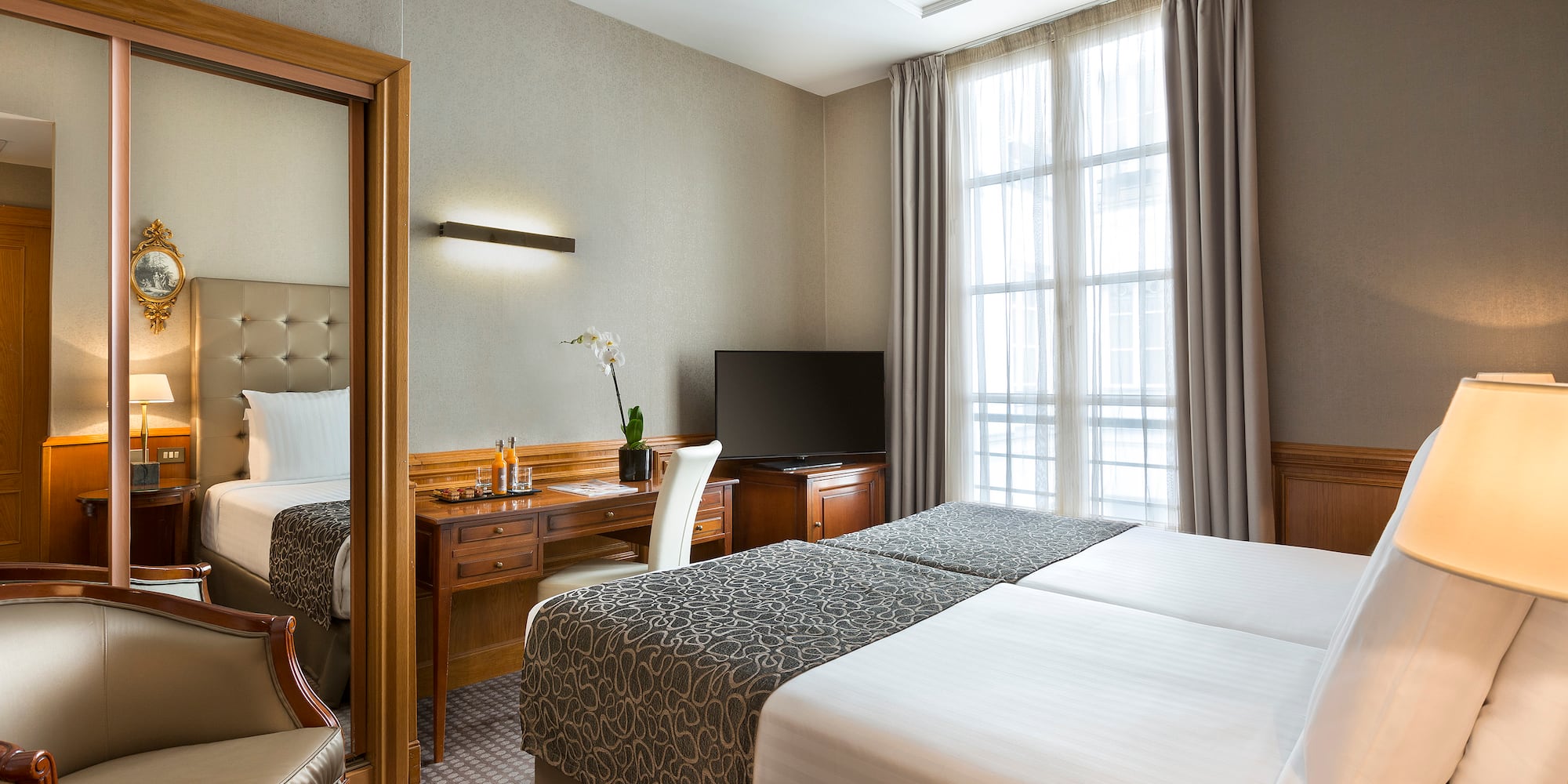 a room with two beds and a desk