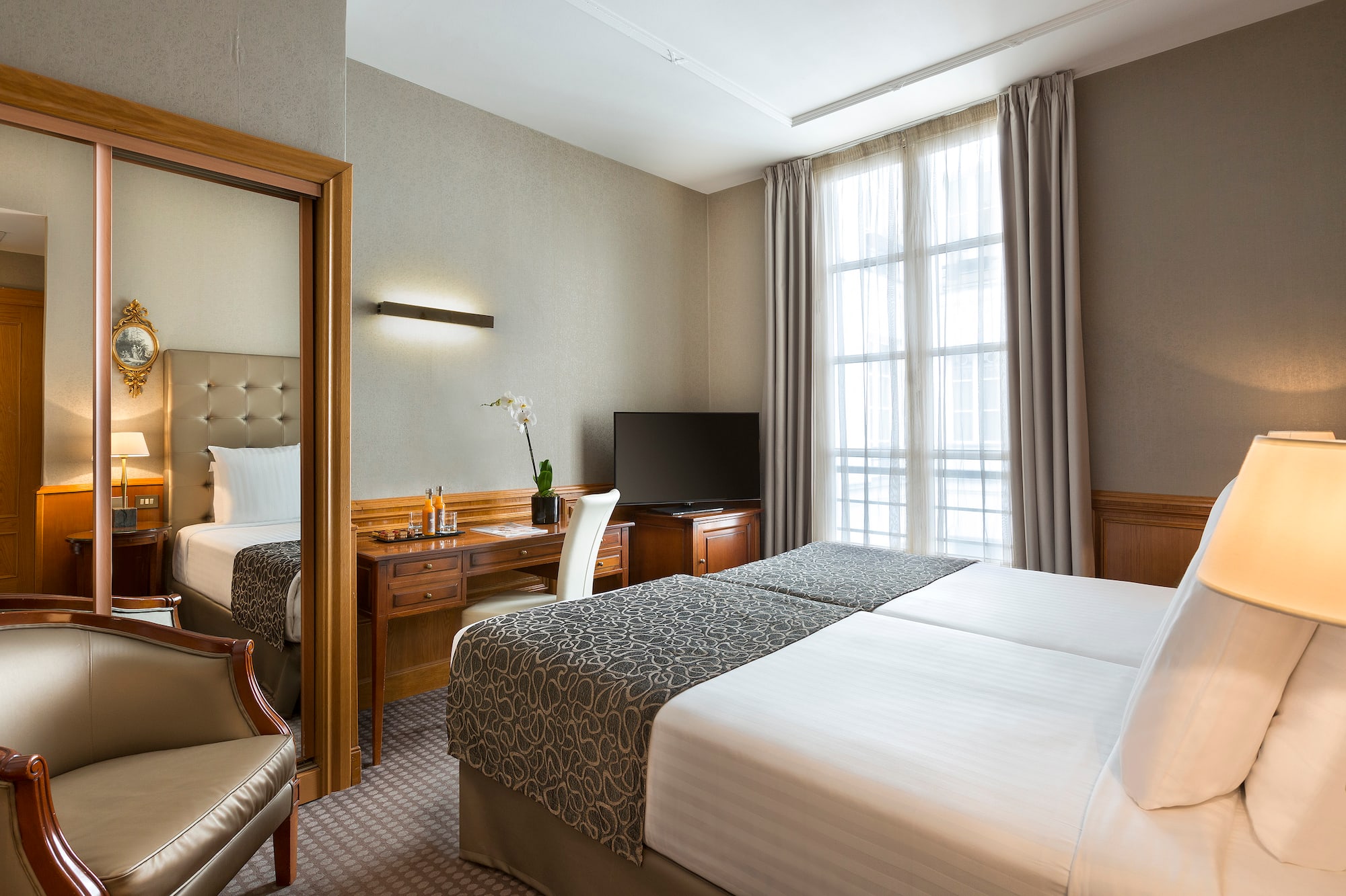 a room with two beds and a desk