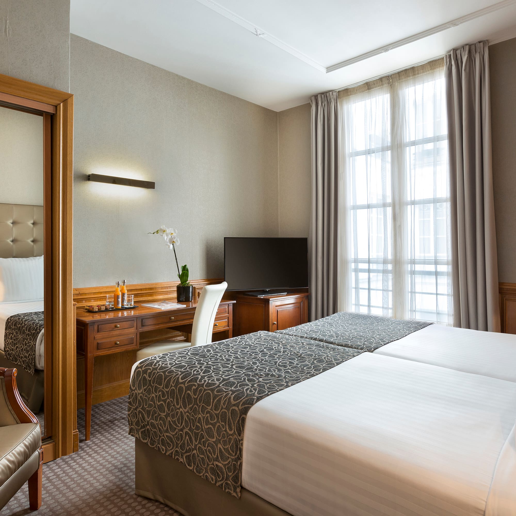 a room with two beds and a desk