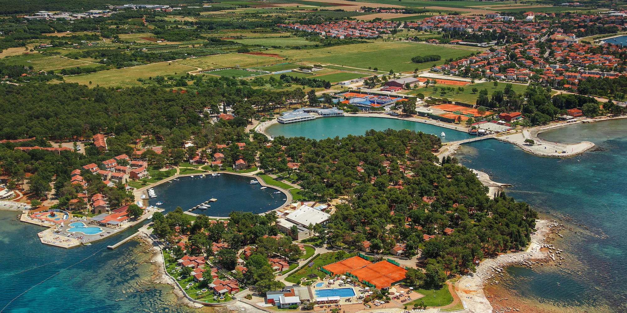an aerial view of a small island with a body of water and a city