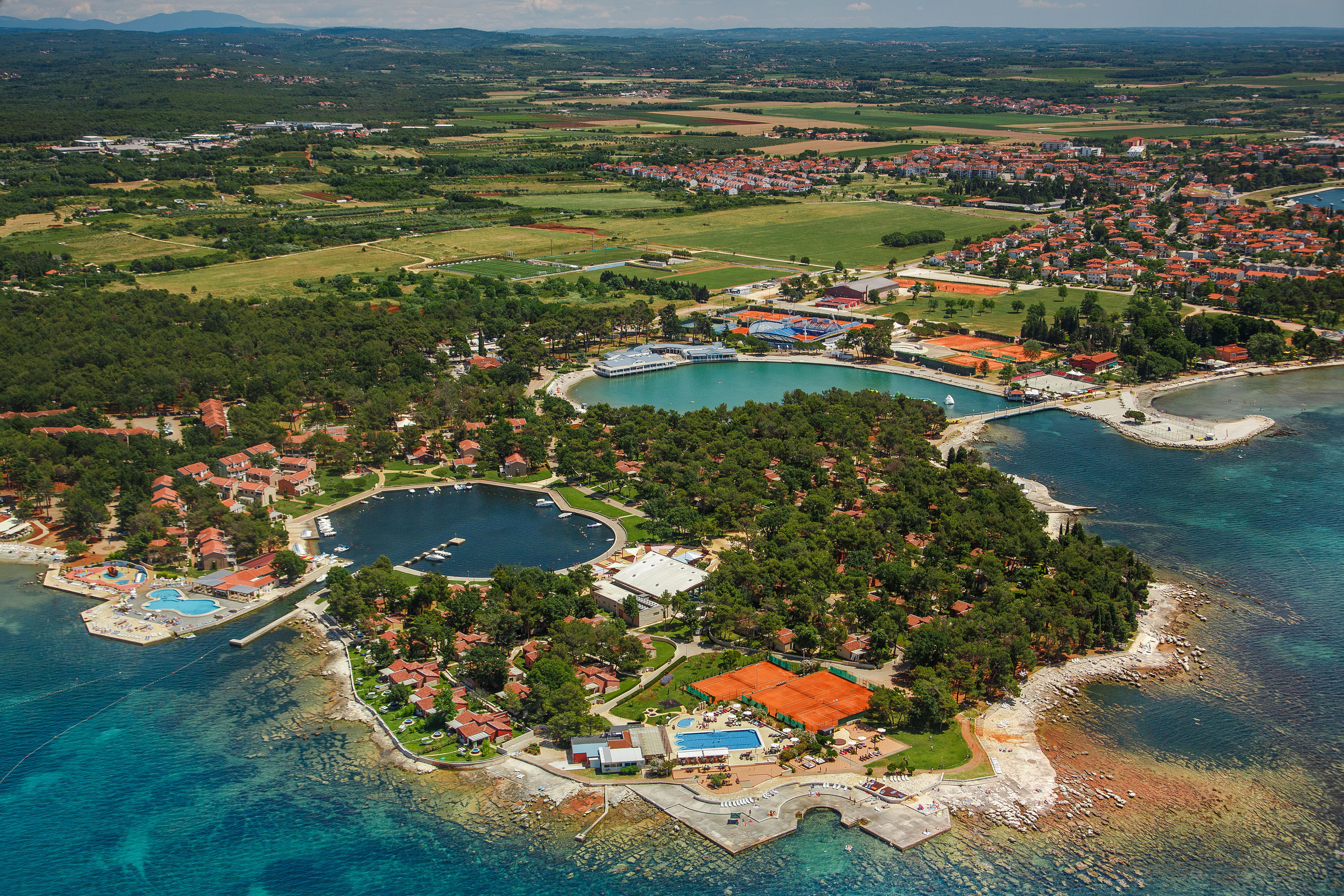 an aerial view of a small island with a body of water and a city