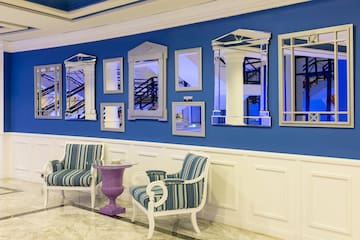 a room with a blue wall and chairs and mirrors