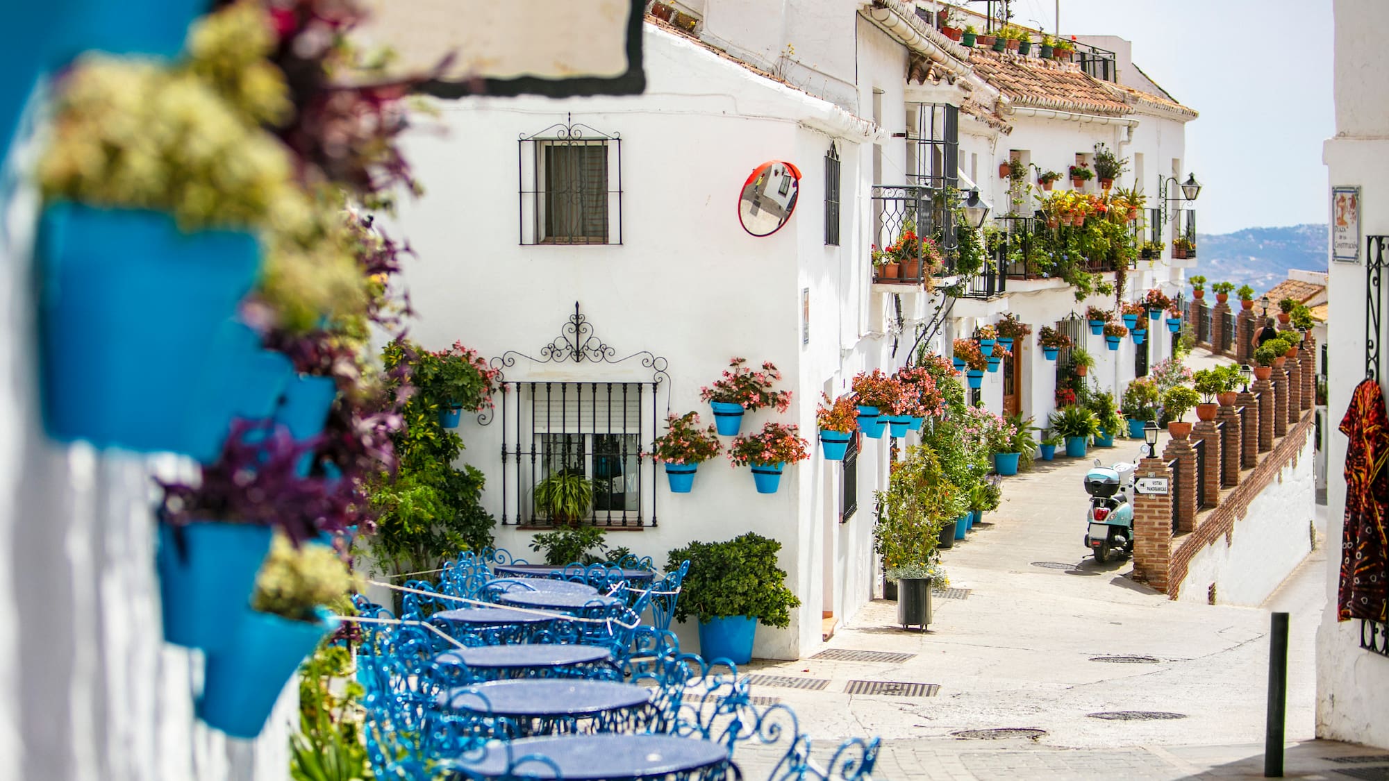 a street with blue tables and chairs