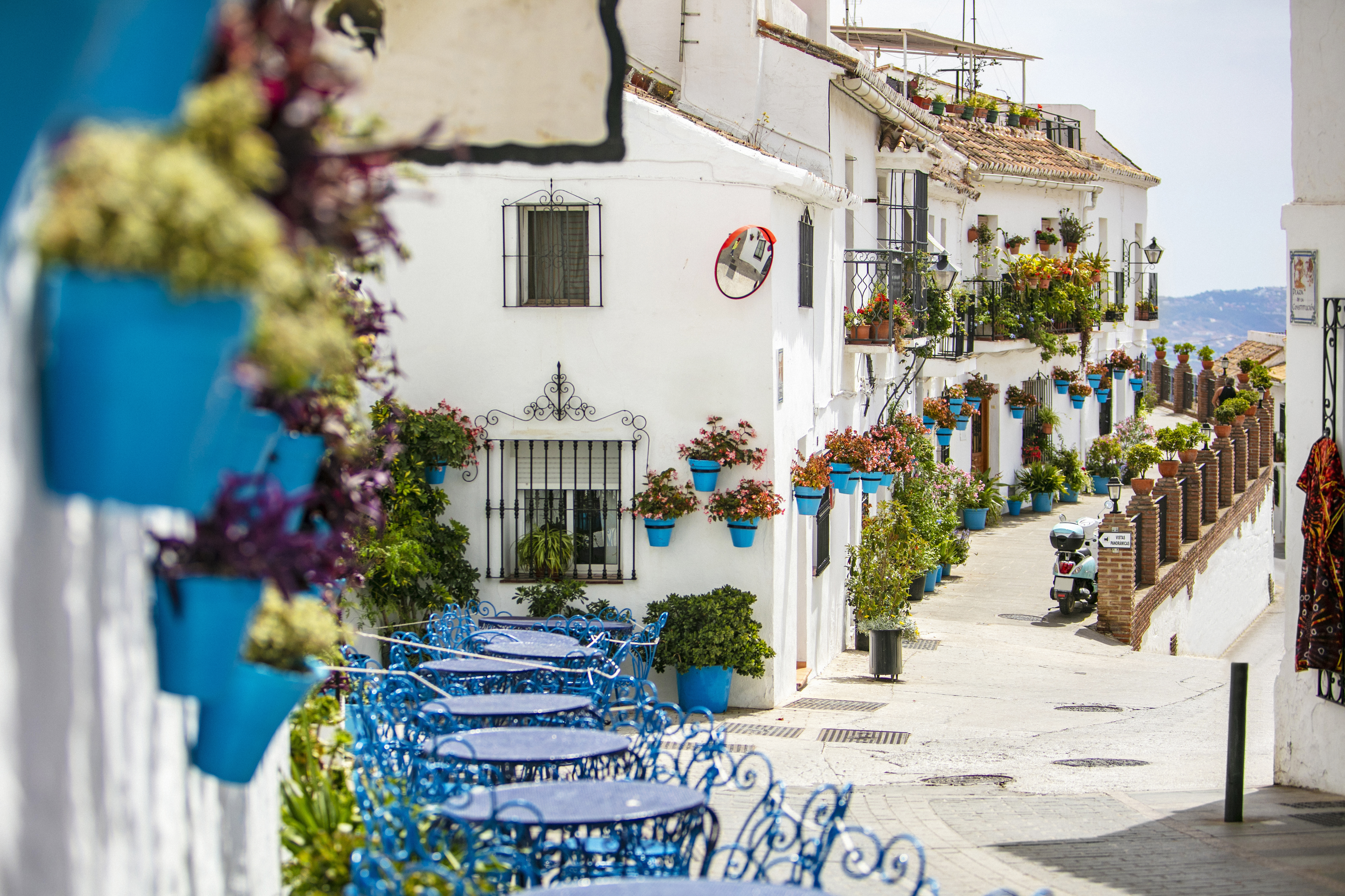 a street with blue tables and chairs