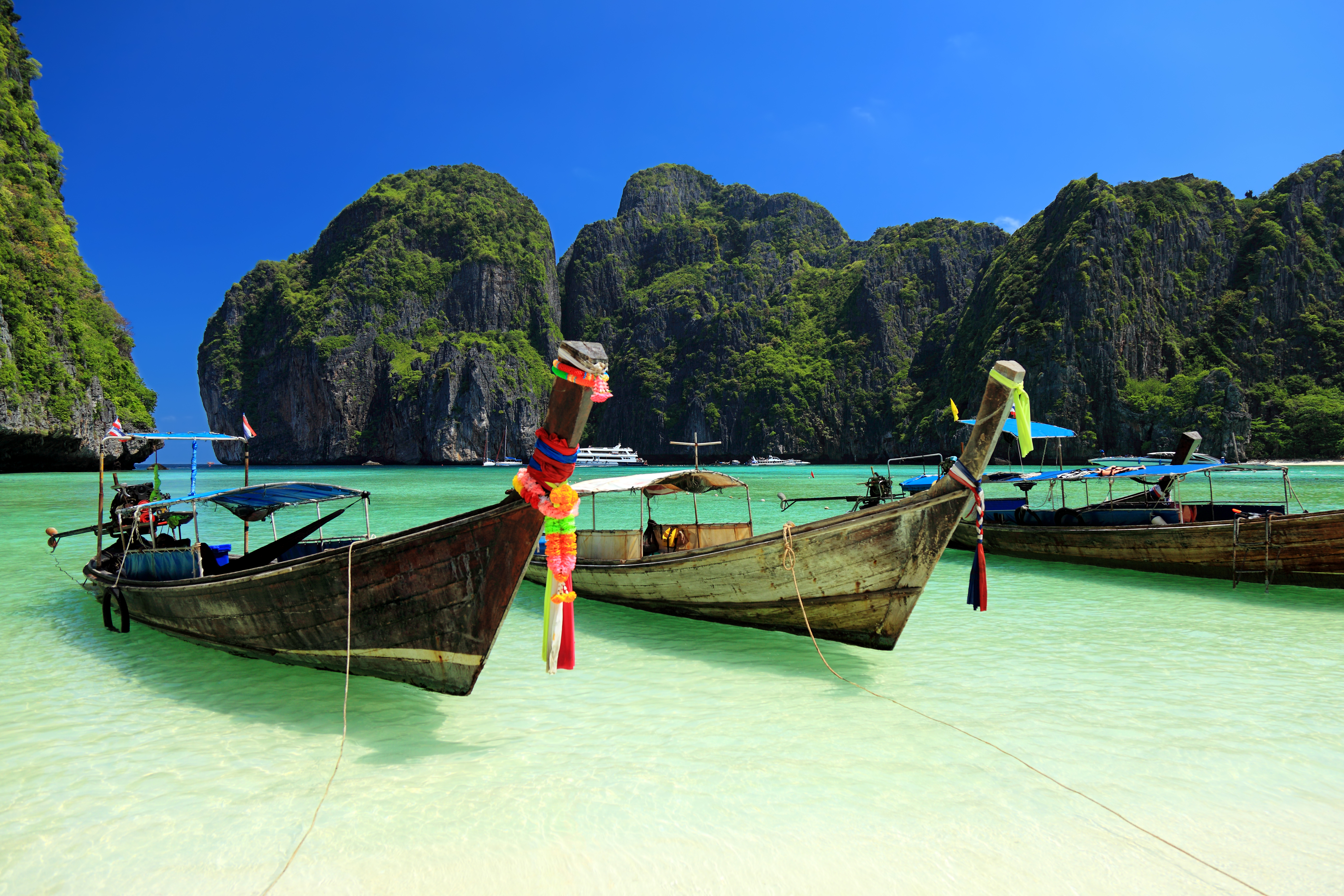 boats in the water with mountains in the background with Phi Phi Islands in the background