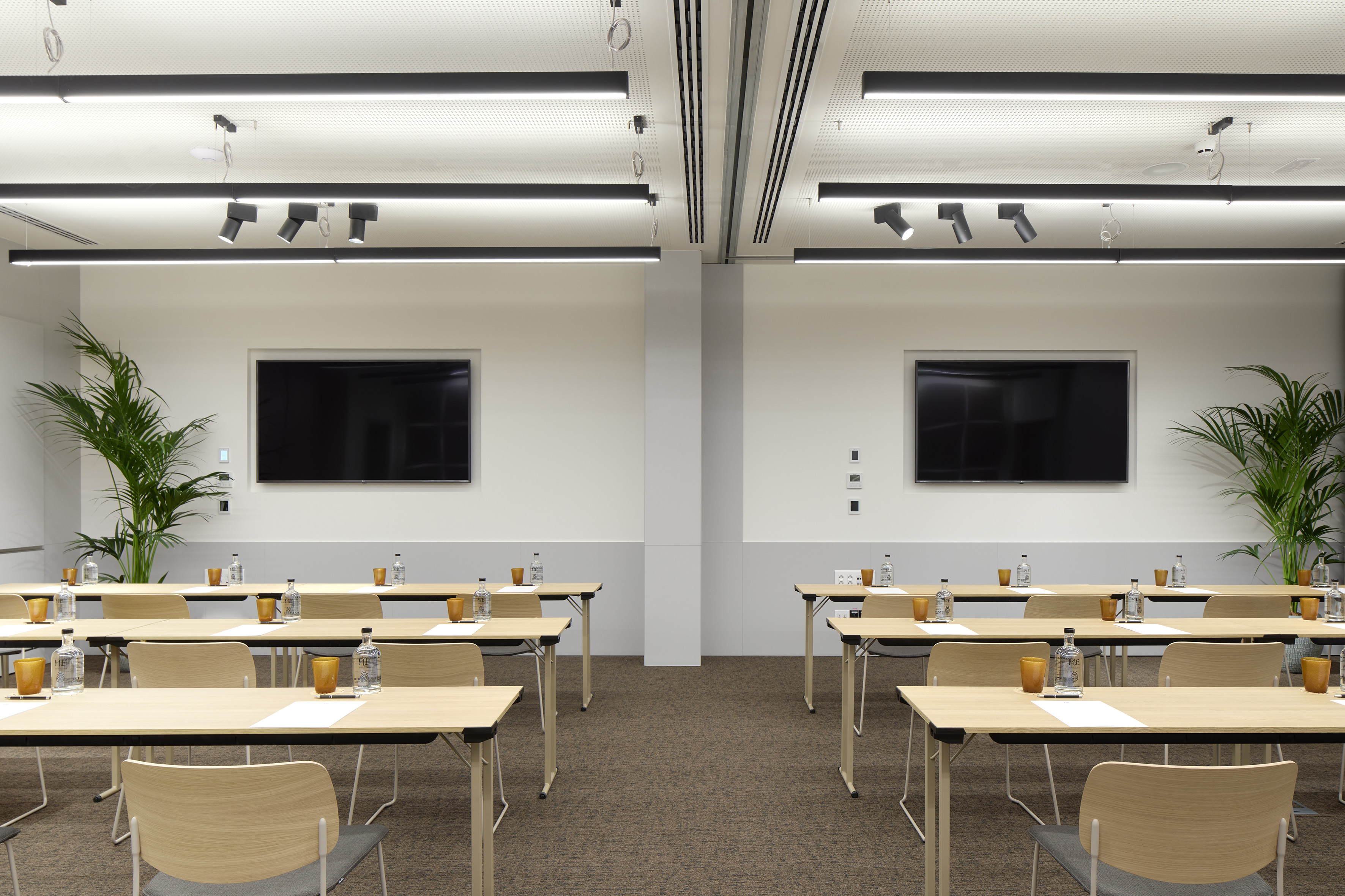 Modern training room with classroom setup, two large screens, and linear lighting. - Studio 4+5 - ME Barcelona, Barcelona