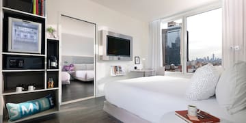 a bedroom with a large bed and a large mirror