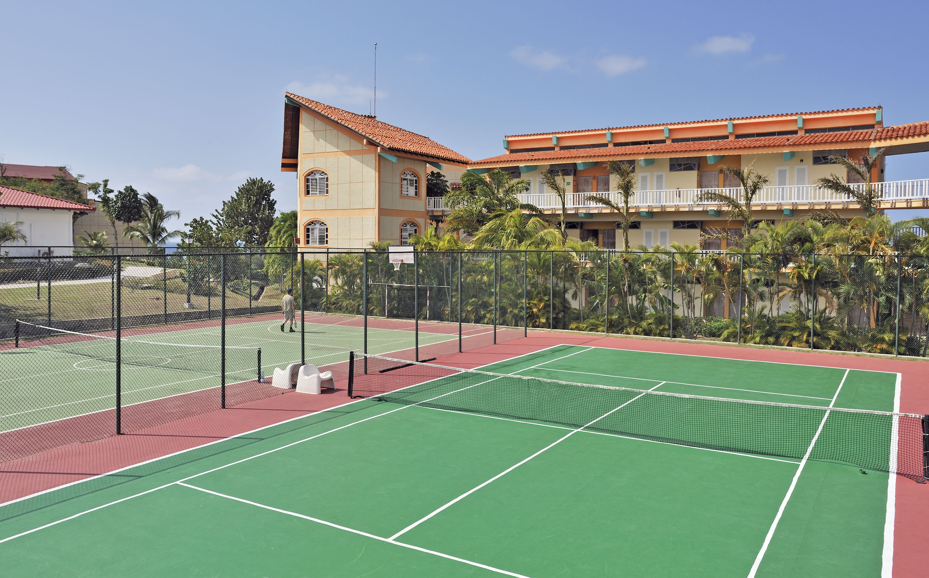 a tennis court with a building in the background