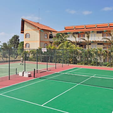 a tennis court with a building in the background