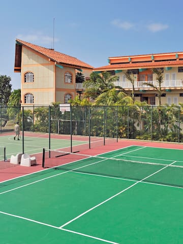 a tennis court with a building in the background